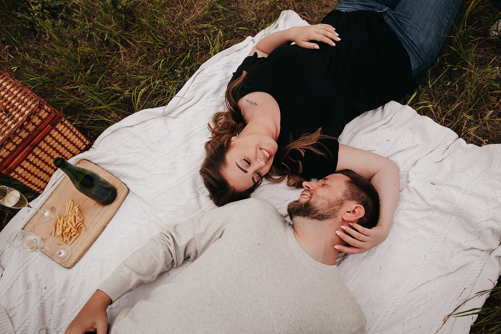 Couple laying down and taking engagement photos