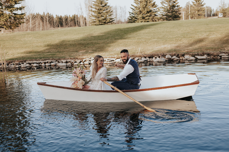 Couple takes photos in canoe at Pine and Pond