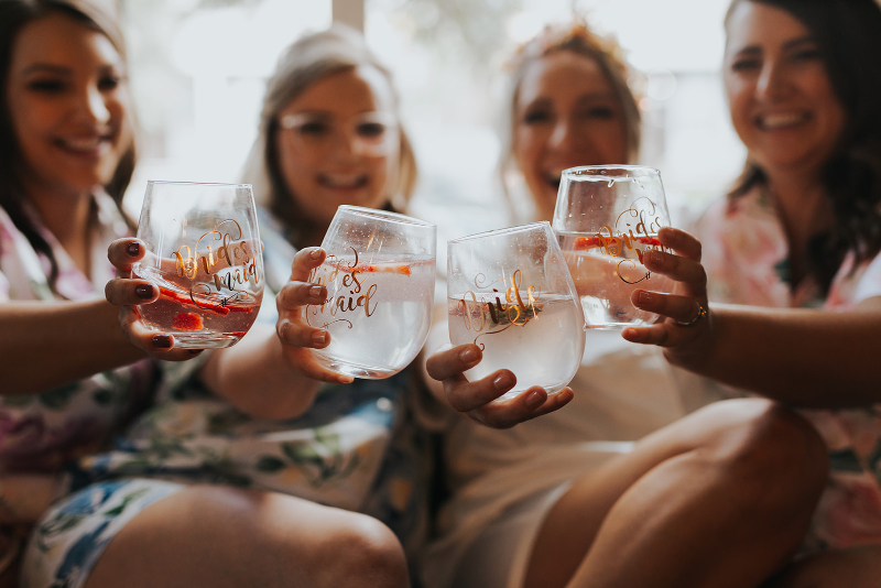 bride and bridesmaids holding wine glasses